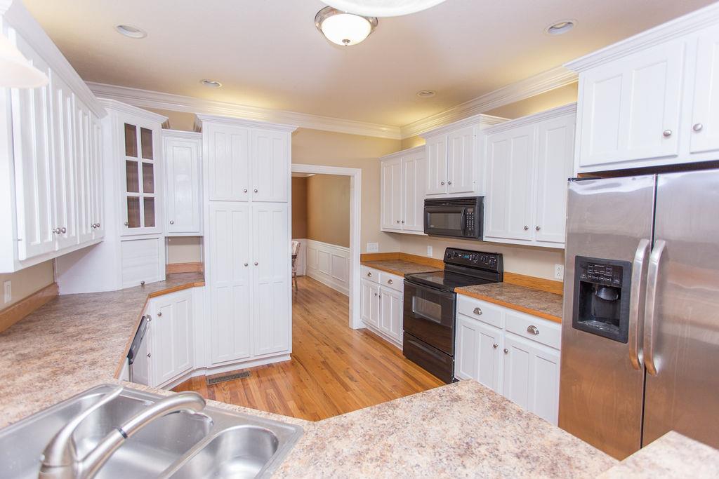 1009 Lake Rise Overlook Gallatin, TN 37066 - Photo 8 of 20 a kitchen with granite countertop a refrigerator a stove top oven a sink dishwasher and wooden cabinets