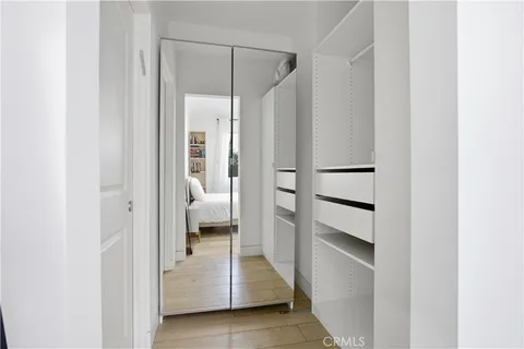 a bathroom with a walk in closet and a large mirror