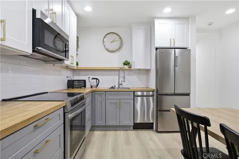 a kitchen with stainless steel appliances granite countertop a refrigerator a stove a sink and a microwave