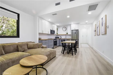 a living room filled with furniture and a dining table