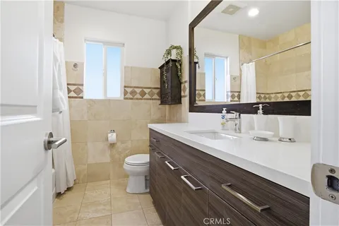 a bathroom with a double vanity sink toilet and mirror