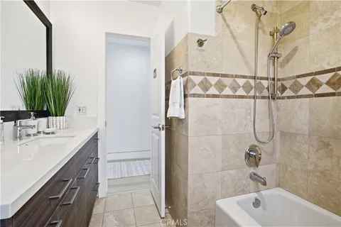 a bathroom with a granite countertop sink a mirror and shower