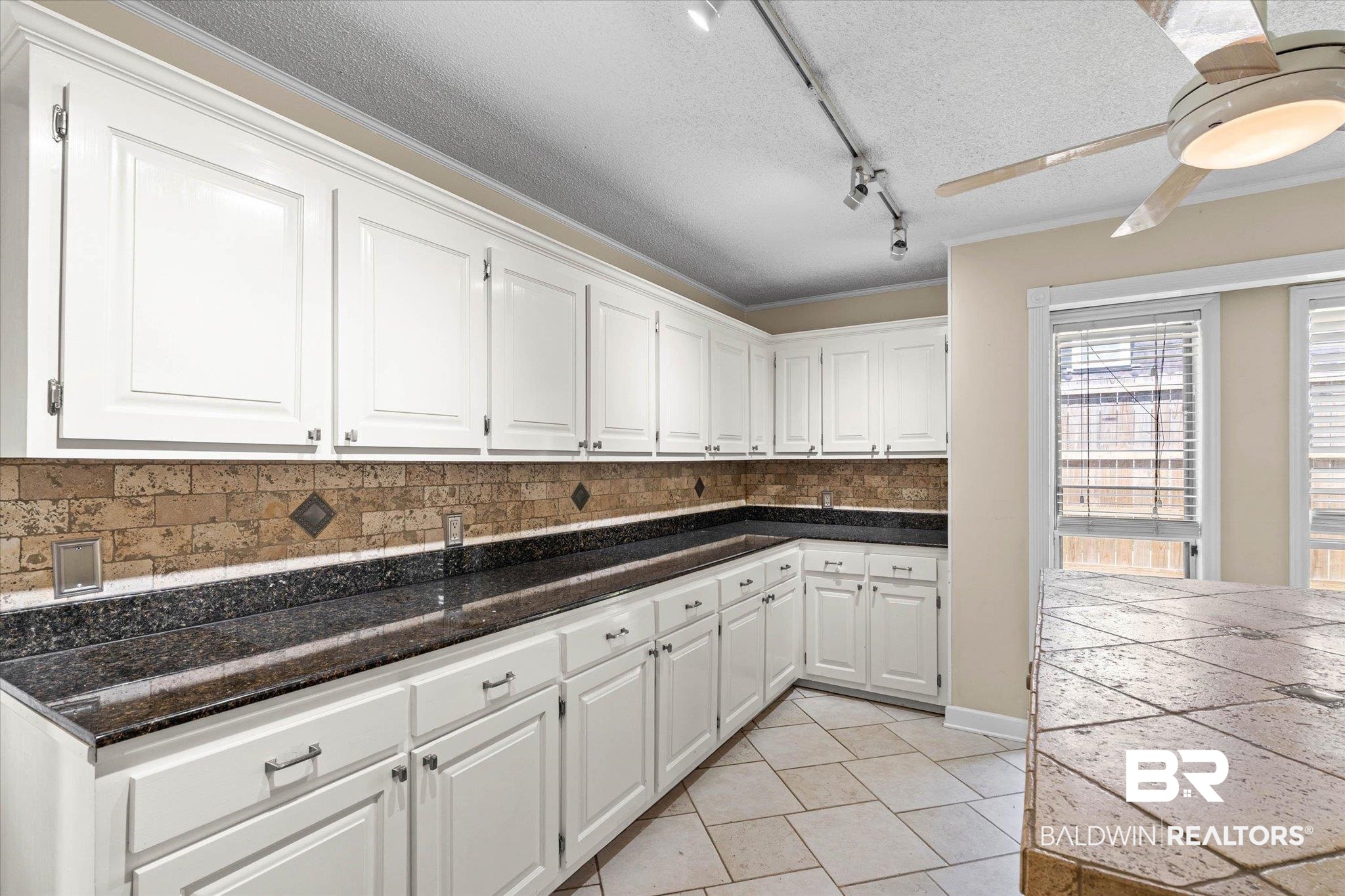 3724 Claridge Road South Mobile, AL 36608 - Photo 11 of 42 Kitchen with white cabinets, tasteful backsplash, a textured ceiling, track lighting, and ornamental molding