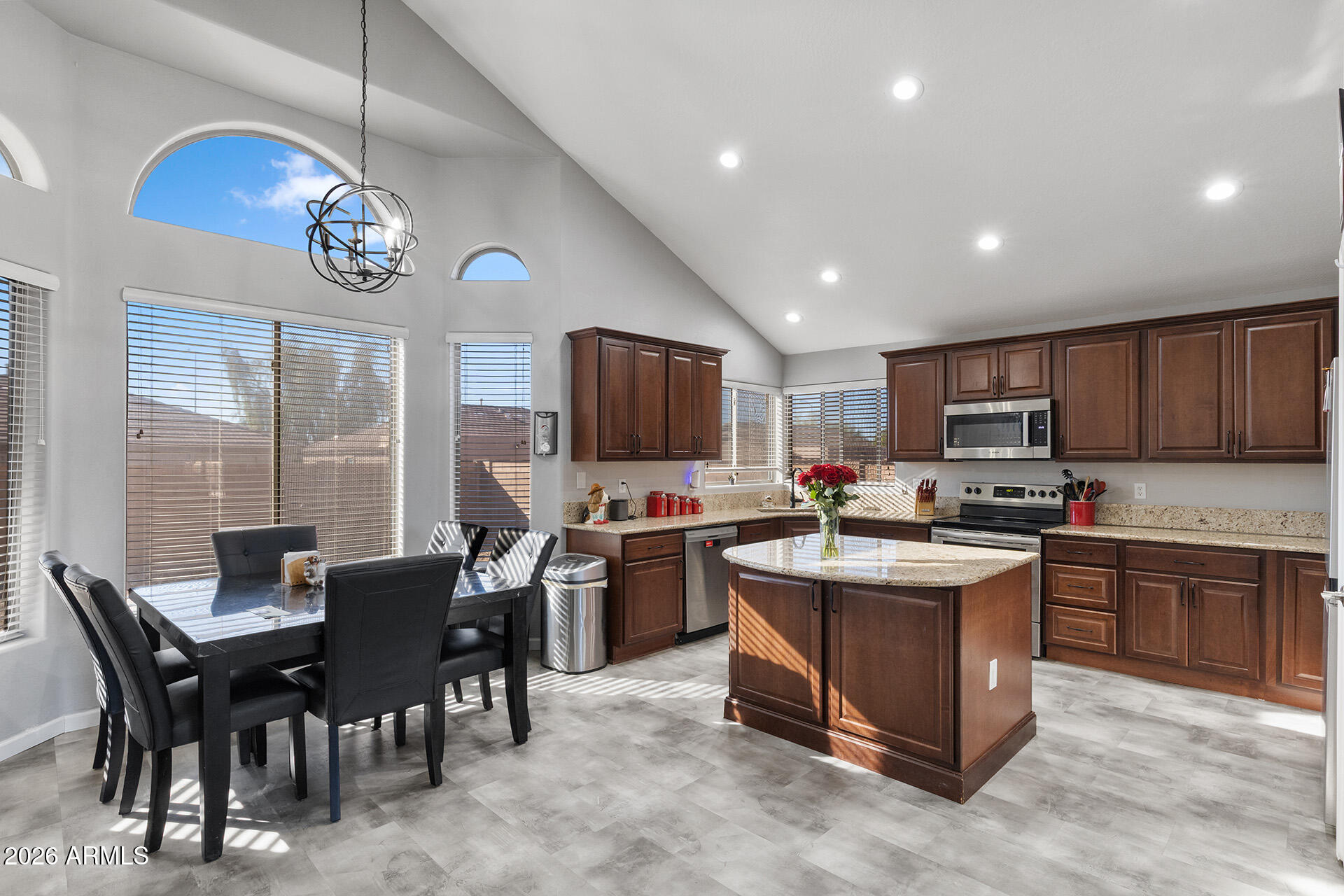 11029 East Decatur Street Mesa, AZ 85207 - Photo 5 of 62 a kitchen with cabinets a sink dishwasher a stove and a dining table with wooden floor