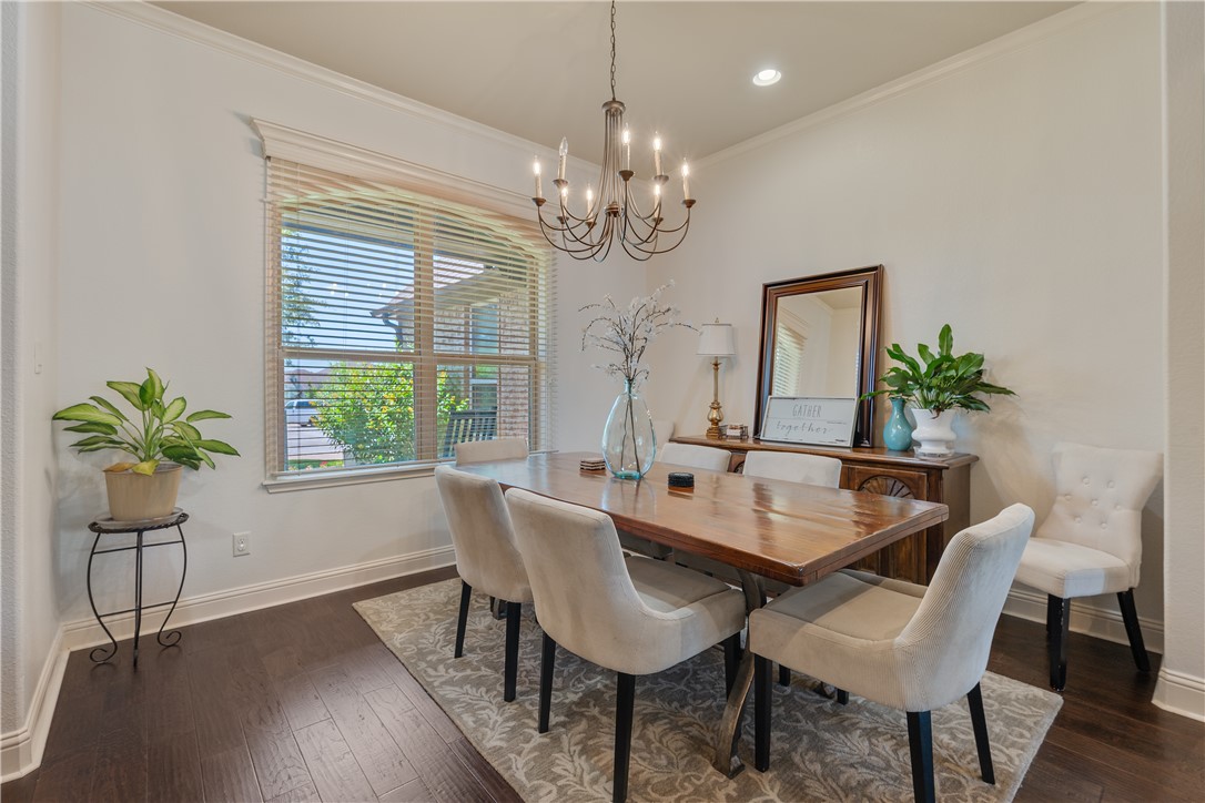 3301 Covington Court Bryan, TX 77808 - Photo 9 of 26 a dining room with furniture a chandelier and wooden floor