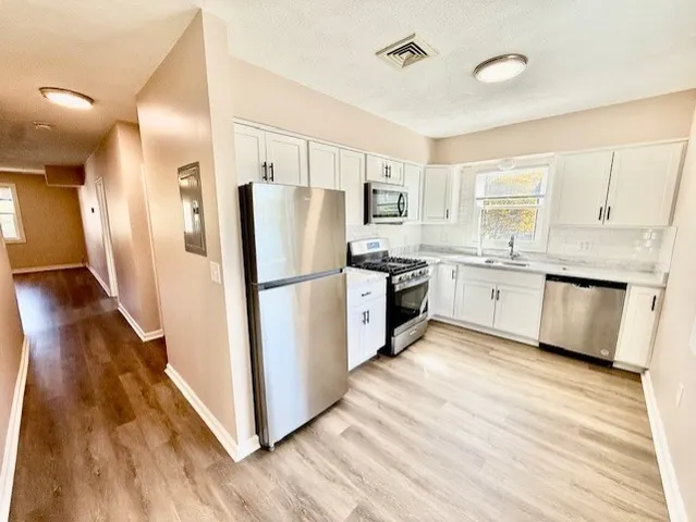 a kitchen with white cabinets and white appliances