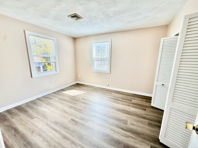 400 Massachusetts Avenue, Unit 4 Arlington, MA 02474 - Photo 11 of 20 a view of an empty room with wooden floor and a window