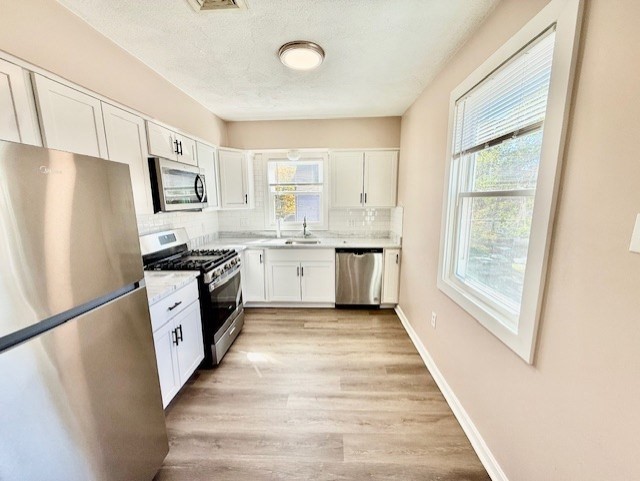 400 Massachusetts Avenue, Unit 4 Arlington, MA 02474 - Photo 2 of 20 a kitchen with white cabinets and white appliances
