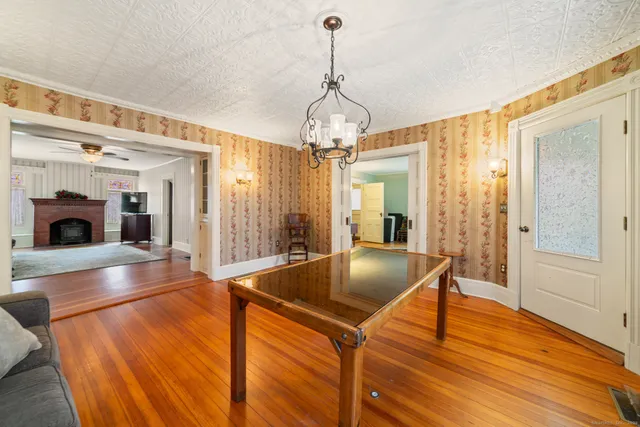 a living room with stainless steel appliances kitchen island granite countertop a sink and a wooden floor