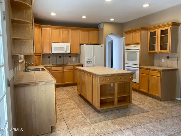 a kitchen with stainless steel appliances granite countertop a stove a sink dishwasher and a refrigerator