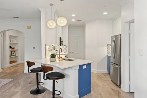 a kitchen with stainless steel appliances granite countertop a table chairs and a refrigerator
