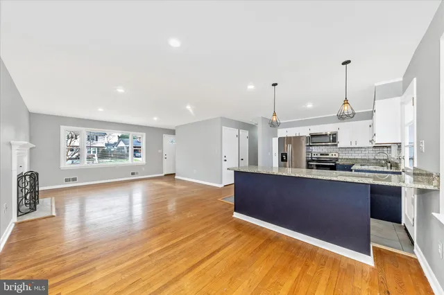 a large kitchen with kitchen island a sink stainless steel appliances and cabinets