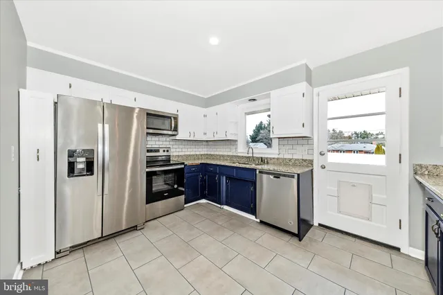 a kitchen with stainless steel appliances granite countertop a refrigerator and a stove top oven