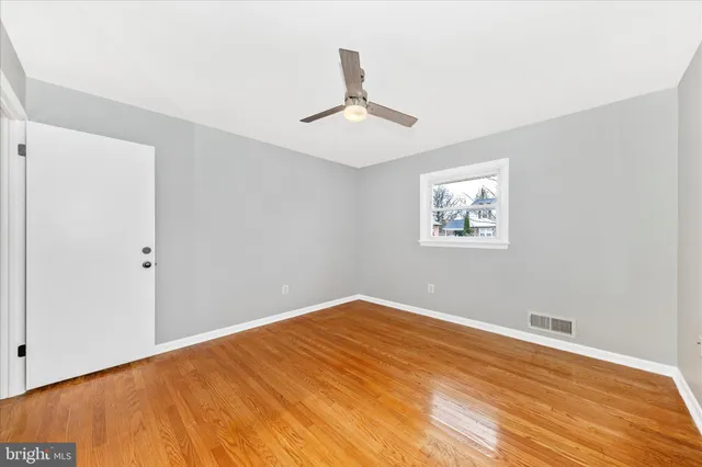 a view of empty room with wooden floor