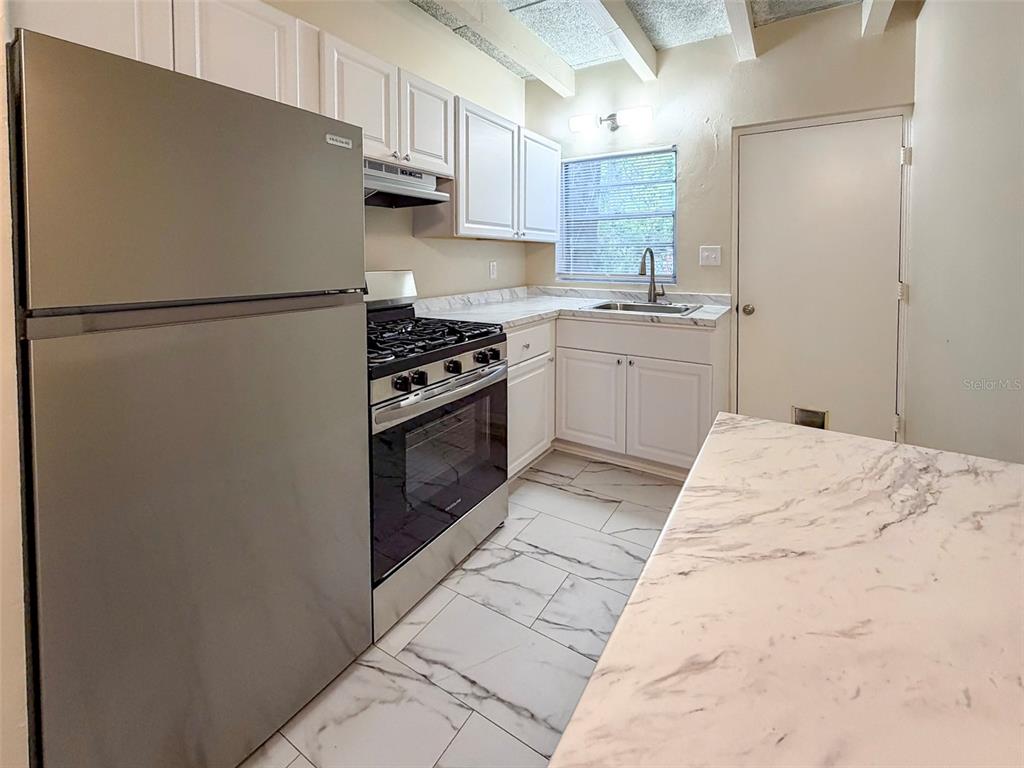 219 Northwest 3rd Avenue, Unit B Gainesville, FL 32601 - Photo 3 of 20 a kitchen with a refrigerator stove and a sink