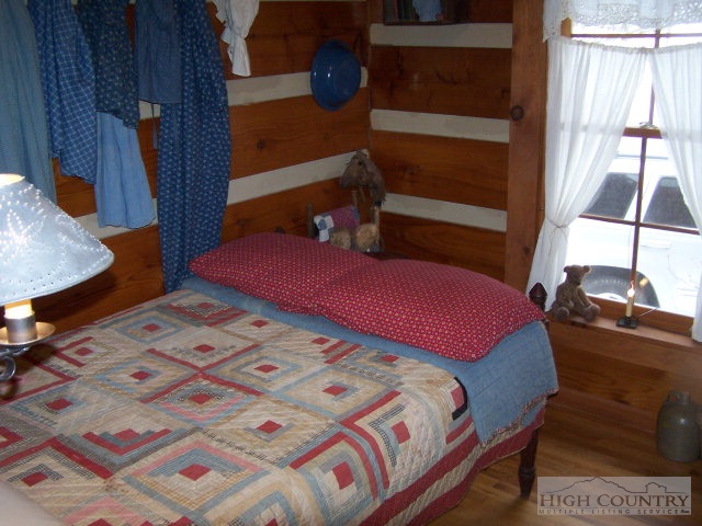 239 Weaver Road Warrensville, NC 28693 - Photo 7 of 22 a bedroom with a bed and a dresser next to a window