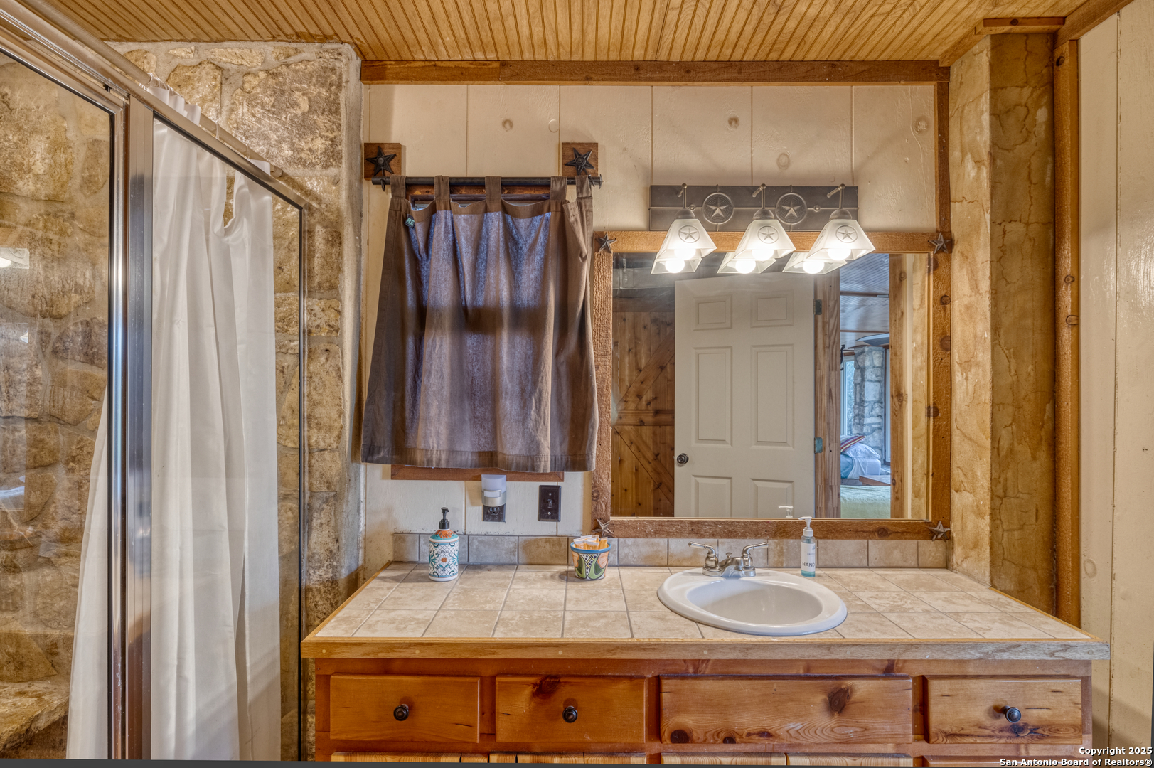 186 Cat Claw Mountain Road Concan, TX 78838 - Photo 13 of 31 a bathroom with a granite countertop sink and a mirror