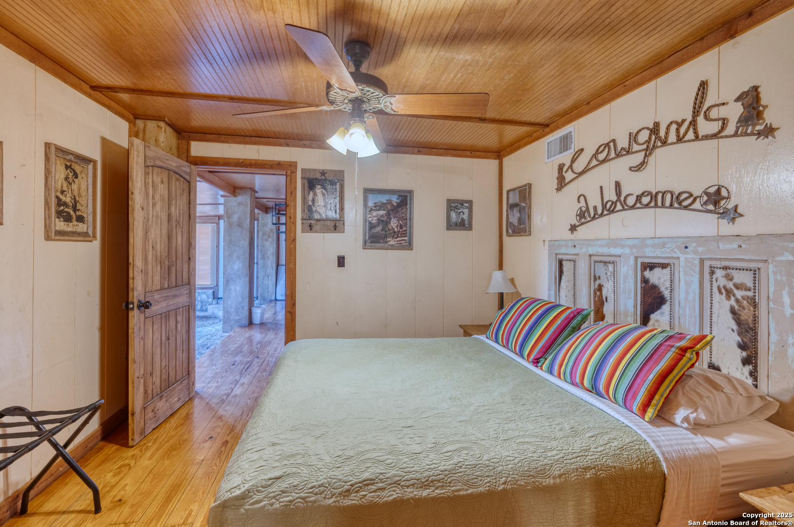 186 Cat Claw Mountain Road Concan, TX 78838 - Photo 15 of 31 a bedroom with a large bed and a chandelier