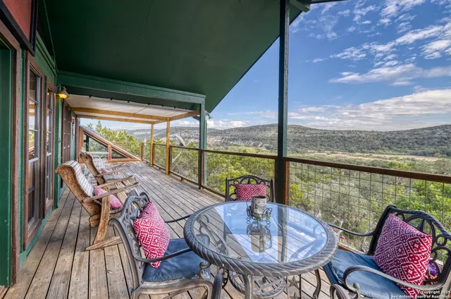 a balcony with wooden floor and outdoor seating