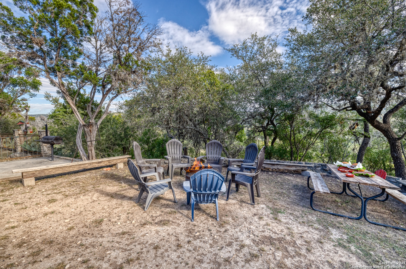 186 Cat Claw Mountain Road Concan, TX 78838 - Photo 26 of 31 a backyard of a house with barbeque oven table and chairs