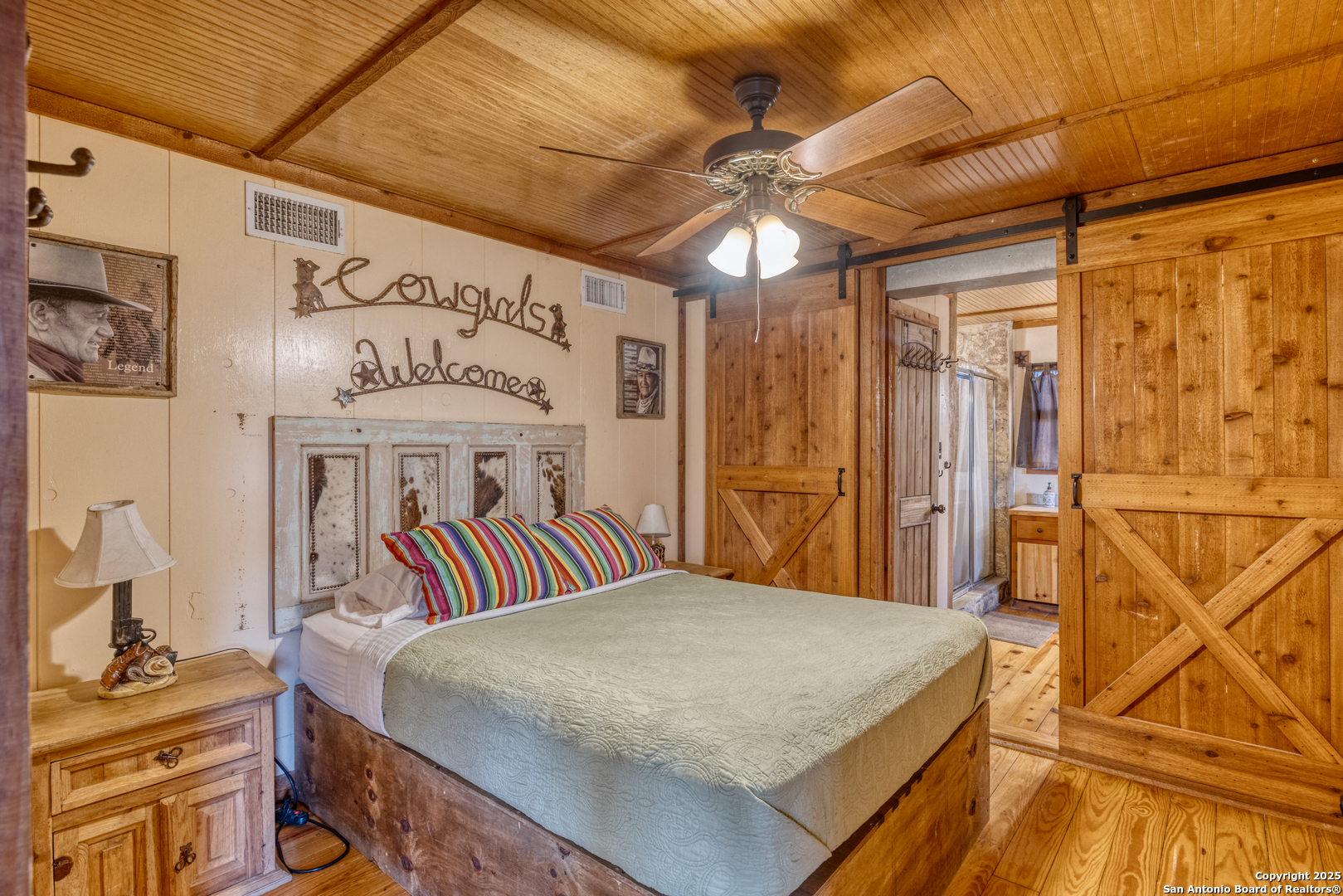 186 Cat Claw Mountain Road Concan, TX 78838 - Photo 9 of 31 a bedroom with a bed and a chandelier