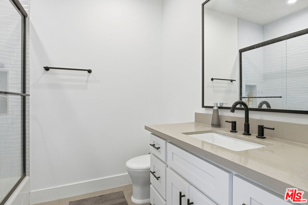 13822 Oxnard Street Van Nuys, CA 91401 - Photo 13 of 23 a bathroom with a sink toilet and vanity