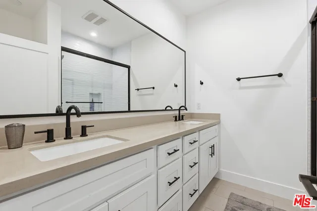 a bathroom with a double vanity sink and a mirror