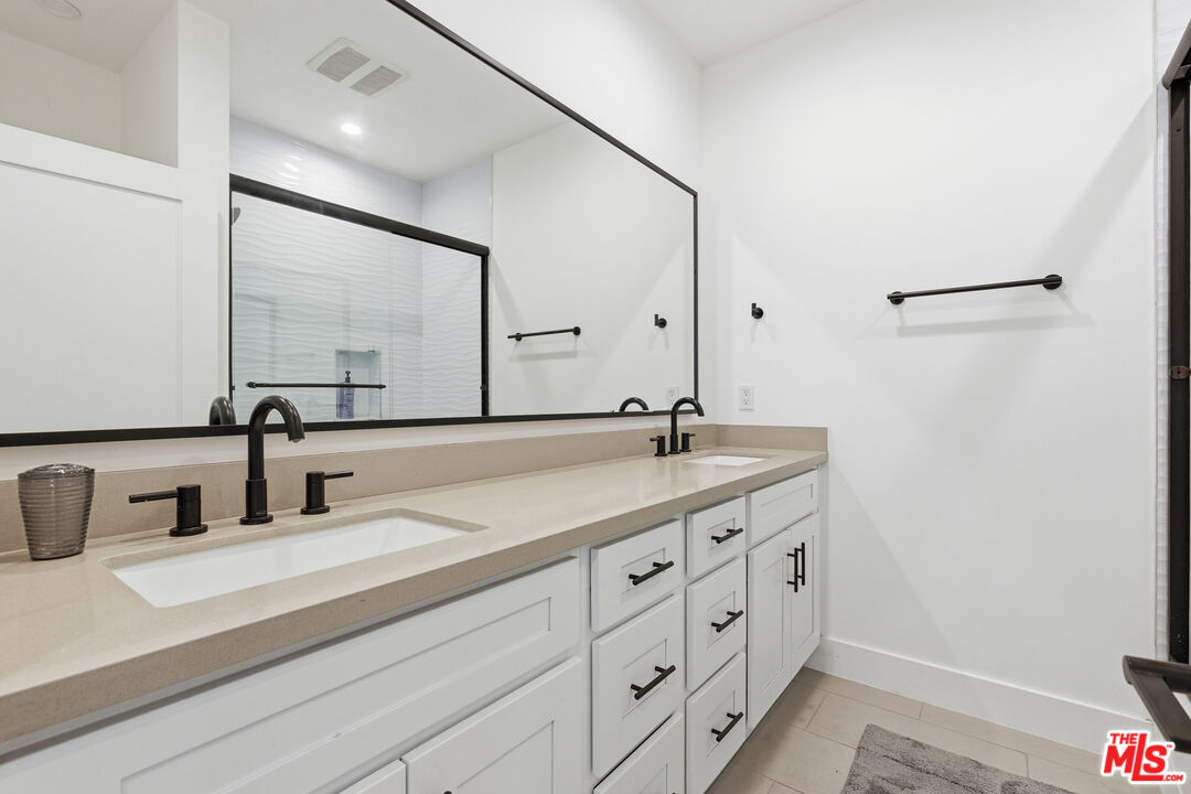 13822 Oxnard Street Van Nuys, CA 91401 - Photo 16 of 23 a bathroom with a double vanity sink and a mirror