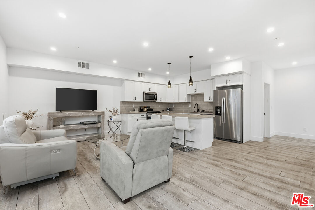 13822 Oxnard Street Van Nuys, CA 91401 - Photo 3 of 23 a living room with furniture and a flat screen tv