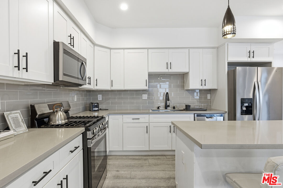 13822 Oxnard Street Van Nuys, CA 91401 - Photo 5 of 23 a kitchen with stainless steel appliances granite countertop a sink stove and refrigerator