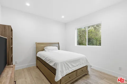 a bed sitting in a bedroom next to a window