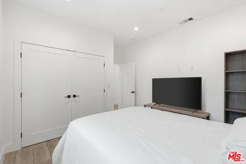 a bedroom with a bed and a flat tv screen