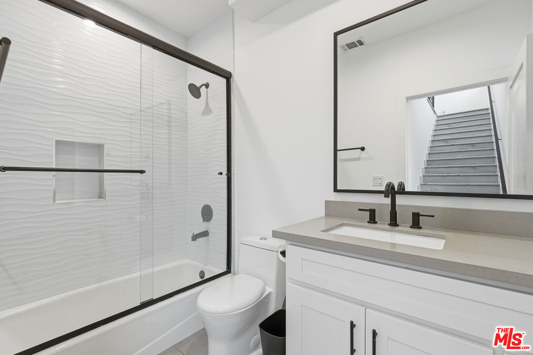 13822 Oxnard Street Van Nuys, CA 91401 - Photo 9 of 23 a bathroom with a granite countertop sink toilet and shower