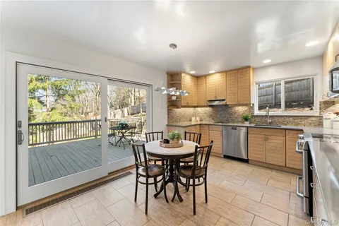 a kitchen with a dining table chairs and sink