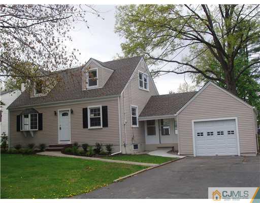 135 Midfield Road Colonia, NJ 07067 - Photo 2 of 18 a front view of a house with a yard and garage