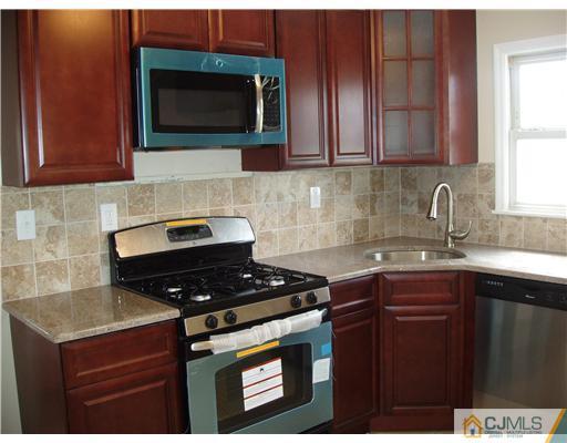 135 Midfield Road Colonia, NJ 07067 - Photo 4 of 18 a kitchen with stainless steel appliances granite countertop a stove a sink and a microwave
