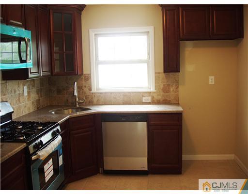 135 Midfield Road Colonia, NJ 07067 - Photo 5 of 18 a kitchen with a sink a stove and cabinets