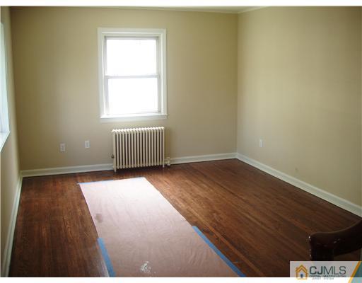135 Midfield Road Colonia, NJ 07067 - Photo 8 of 18 an empty room with wooden floor