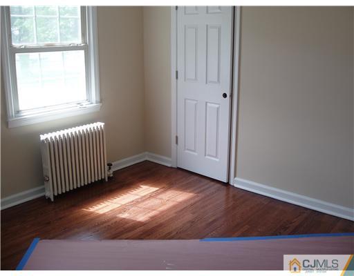 135 Midfield Road Colonia, NJ 07067 - Photo 9 of 18 an empty room with wooden floor and windows
