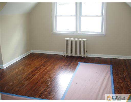 135 Midfield Road Colonia, NJ 07067 - Photo 10 of 18 an empty room with wooden floor and windows