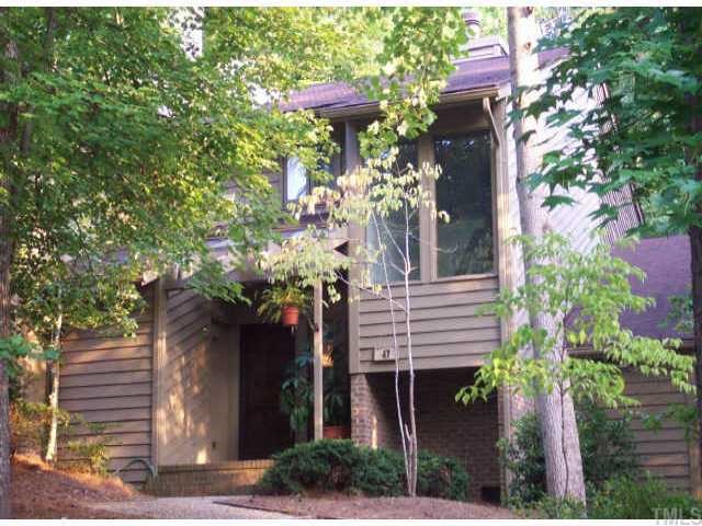 a front view of a house with a yard and a chair