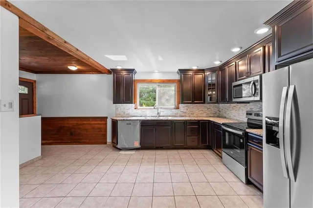 a large kitchen with a large counter top stainless steel appliances and cabinets