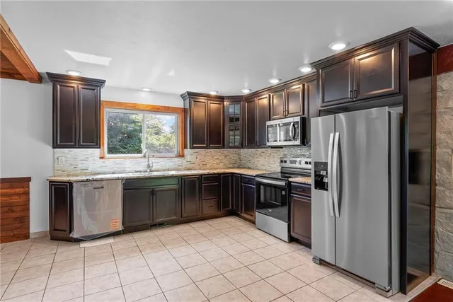 a kitchen with stainless steel appliances granite countertop a refrigerator and a sink