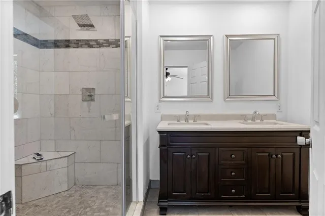 a bathroom with a granite countertop sink a toilet and shower