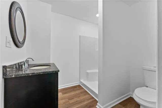 a bathroom with a granite countertop toilet sink and mirror