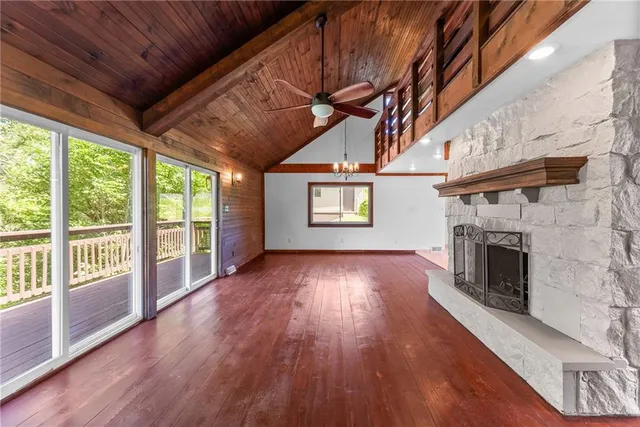 a view of empty room with wooden floor fireplace and windows