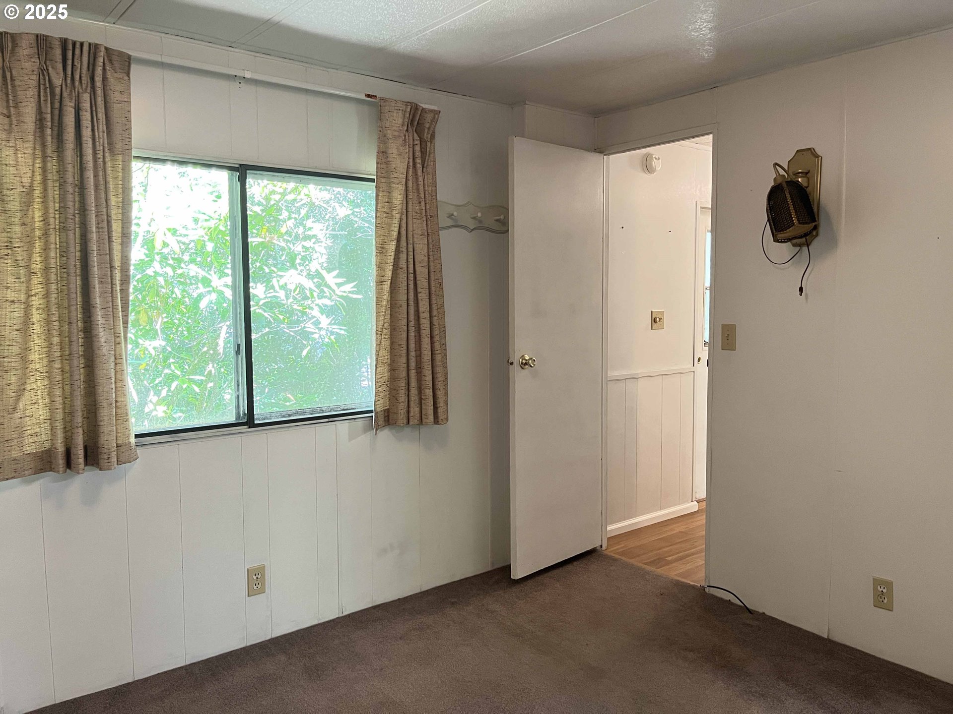 1600 Rhododendron Drive, Unit 261 Florence, OR 97439 - Photo 27 of 42 an empty room with a window and a ceiling fan