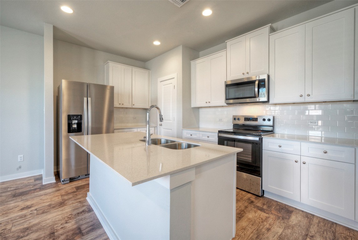 2312 Castillo Drive Round Rock, TX 78664 - Photo 9 of 21 a kitchen with stainless steel appliances granite countertop a sink stove refrigerator and cabinets