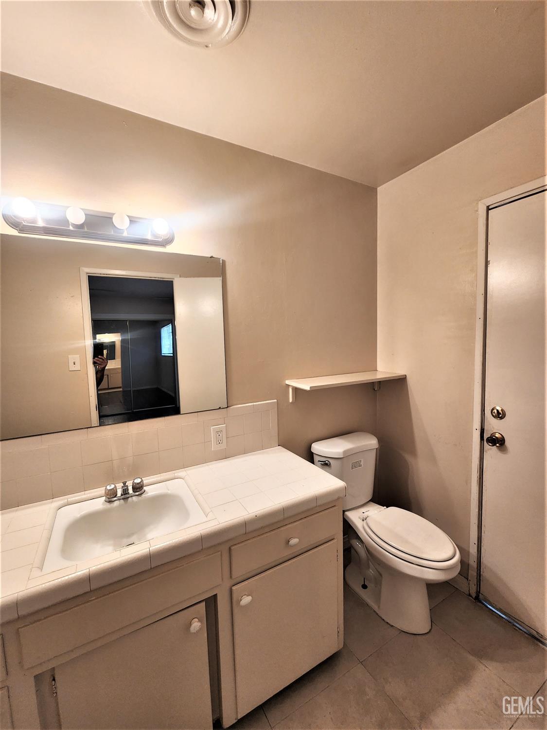 Undisclosed Address Bakersfield, CA 93306 - Photo 13 of 18 a bathroom with a toilet a sink and mirror