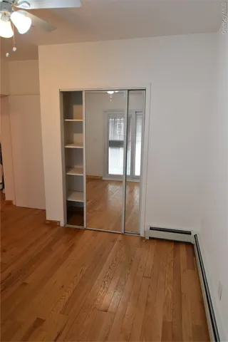 an empty room with wooden floor and closet